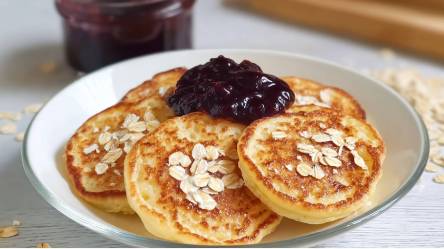 Teller mit Quark-Haferflocken-Pancakes und Heidelbeerkompott obendrauf