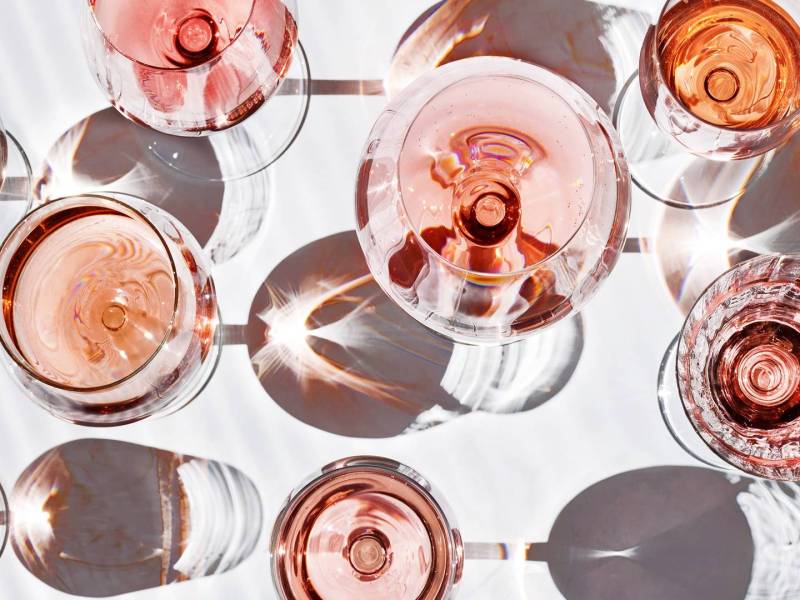 Draufsicht: Viele verschiedene Gläser mit Roséwein in unterschiedlichen Farben.