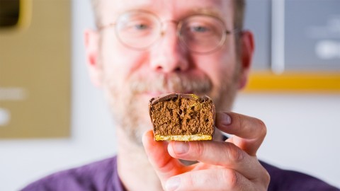 Koch Oli präsentiert einen aufgeschnittenen Schokomoussewürfel.