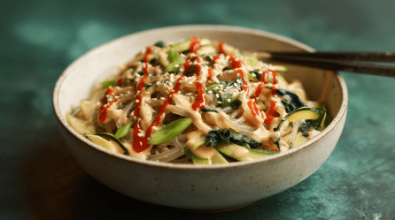 Eine Schale mit Sesamnudeln mit Zoodles und Spinat.