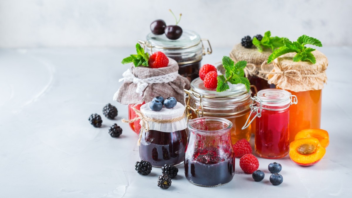 Sommer-Marmeladen: einige Gläser mit Marmelade stehen auf einem hellen Untergrund.