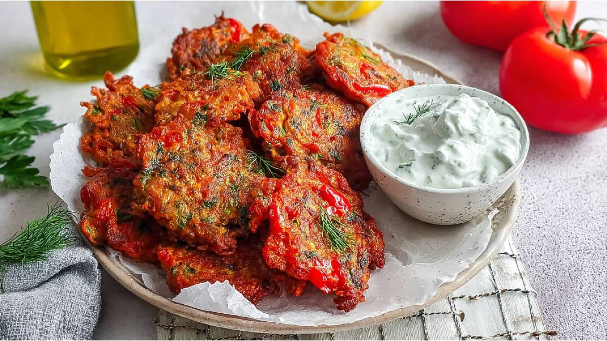 Teller mit mehreren Tomatokeftedes, eine Schale mit hellem Dip daneben