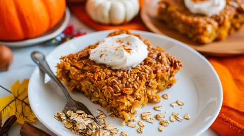 Ein Stück Baked Oats mit Kürbis, serviert mit Mascarponecreme.