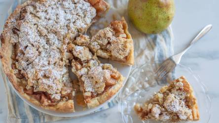 angeschnittener Birnenkuchen mit Marzipanstreuseln auf einem Tisch