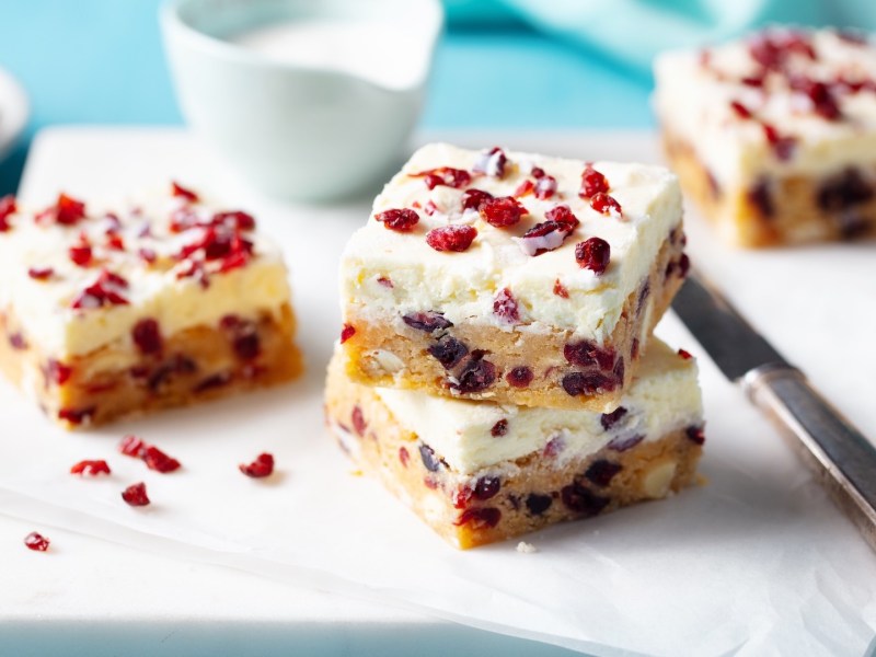 Mehrere Cranberry-Schnitten auf einem Stück weißem Backpapier.