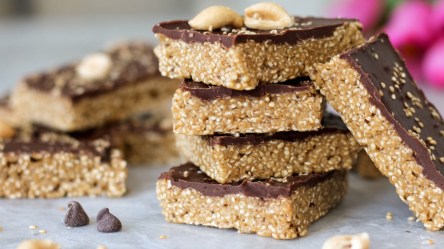 Mehrere übereinander gestapelte Erdnussbutter-Quinoa-Riegel.