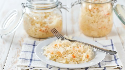 Zwei Gläser und eine Schale fermentierter Krautsalat mit Möhren.