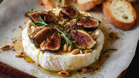 Backblech mit einem Gebackener Camembert mit Feigen und Honig, geröstetes Brot im Hintergrund