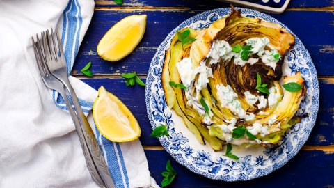 Gebratener Spitzkohl mit Walnusscreme auf einem blau-weiß gemusterten Teller.