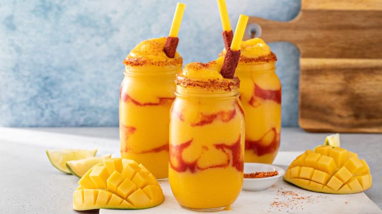 Drei Gläser mit Mangonada, einem mexikanischen Drink aus Mango und Chilisoße.