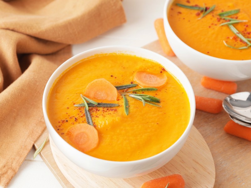 Zwei Schüsseln Möhrensuppe mit Curry.
