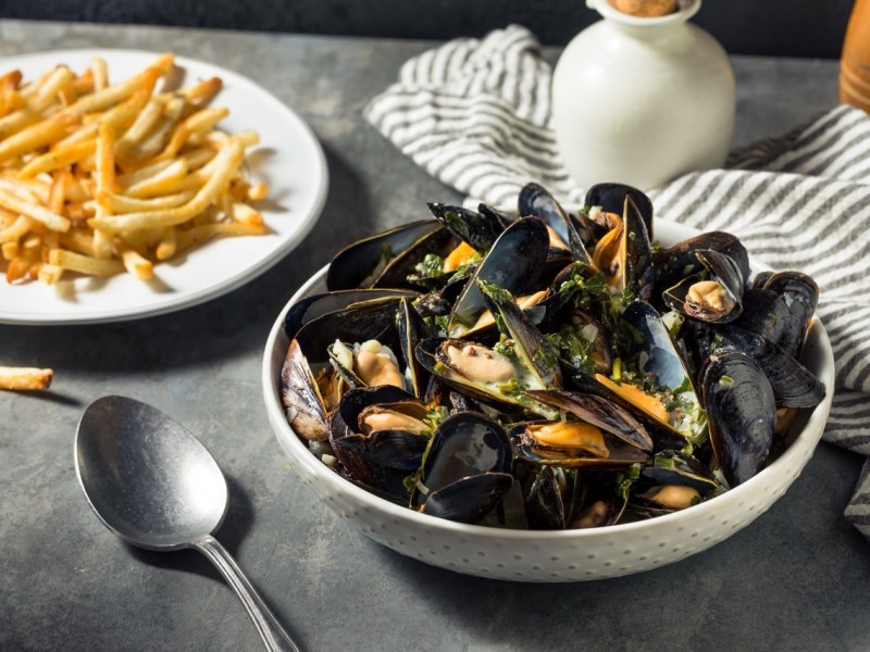 Eine Portion Moules frites, serviert mit Miesmuscheln und Pommes.