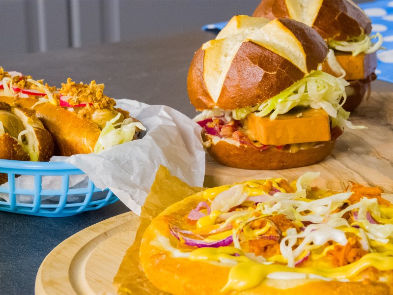 Oktoberfest-Fingerfood auf verschiedenen Brettern und inKörben auf einer dunklen Arbeitsfläche.