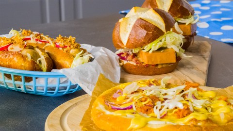 Oktoberfest-Fingerfood auf verschiedenen Brettern und inKörben auf einer dunklen Arbeitsfläche.