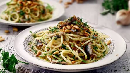 Zwei Teller mit Spaghetti mit Ölsardinen auf einem Tisch
