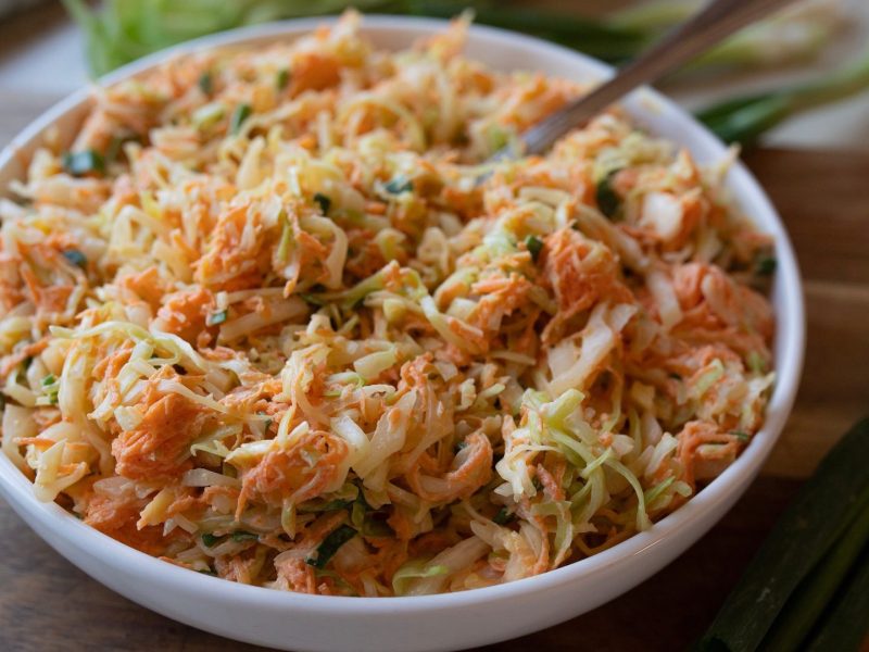 Eine Schale mit Spitzkohl-Möhren-Coleslaw mit Röstzwiebeln.
