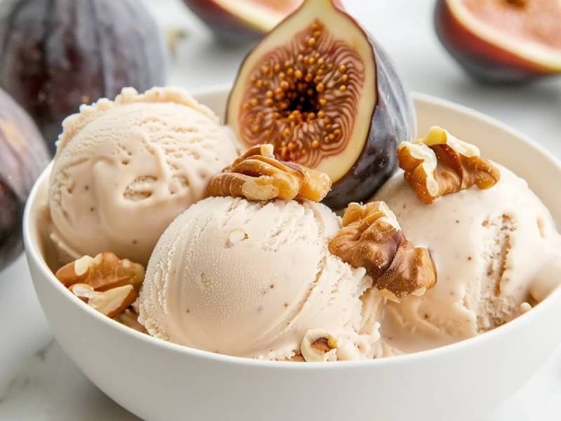 Schale mit einem Feigen-Walnuss-Eis, frische Feigen im Hintergrund