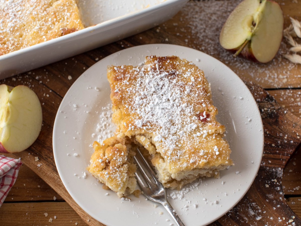 Ein Stück Apfel-Hirse-Auflauf mit einer Gabel auf einem Teller.