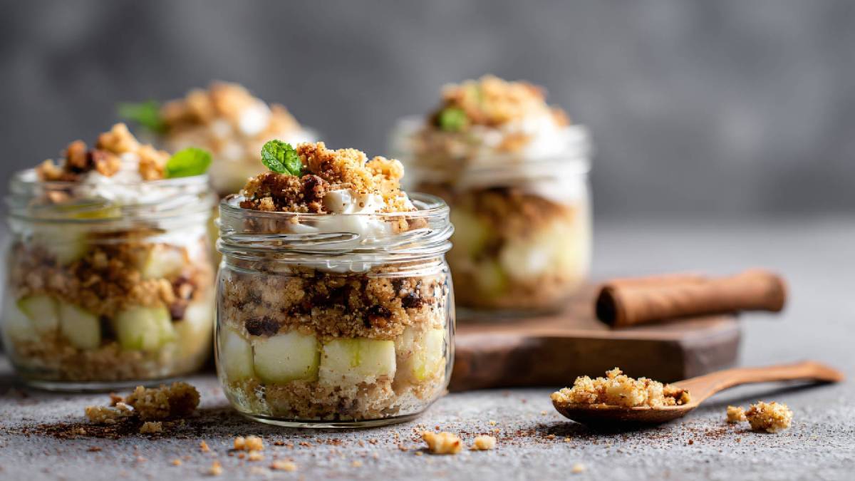 mehrere Gläser mit Apple Crumble im Glas auf einem Tisch