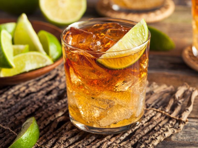 Mehrere Gläser Dark’n Stormy, davon eines im Fokus. Drum herum liegen Limettenspalte.