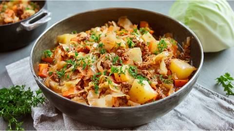 Schale mit Dithmarscher Kohlpfanne, Kohlkopf im Hintergrund