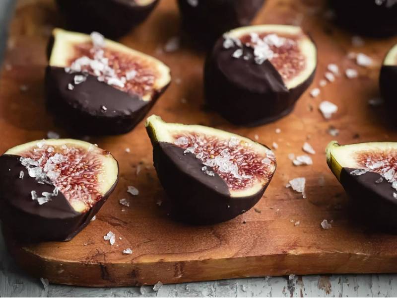 Holzbrett mit Feigen mit Schokolade und Meersalz
