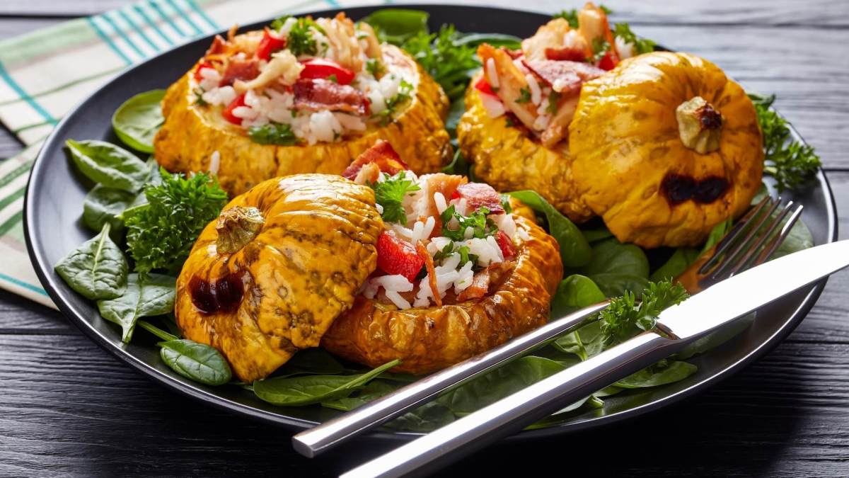 Gefüllter Patisson mit Reis auf einem dunklen Teller.