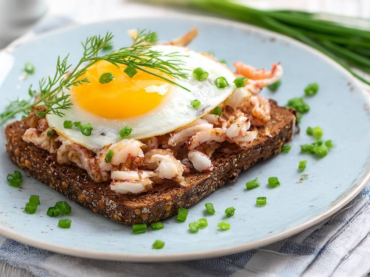 Teller mit einem Halligbrot mit Krabben und Spiegelei