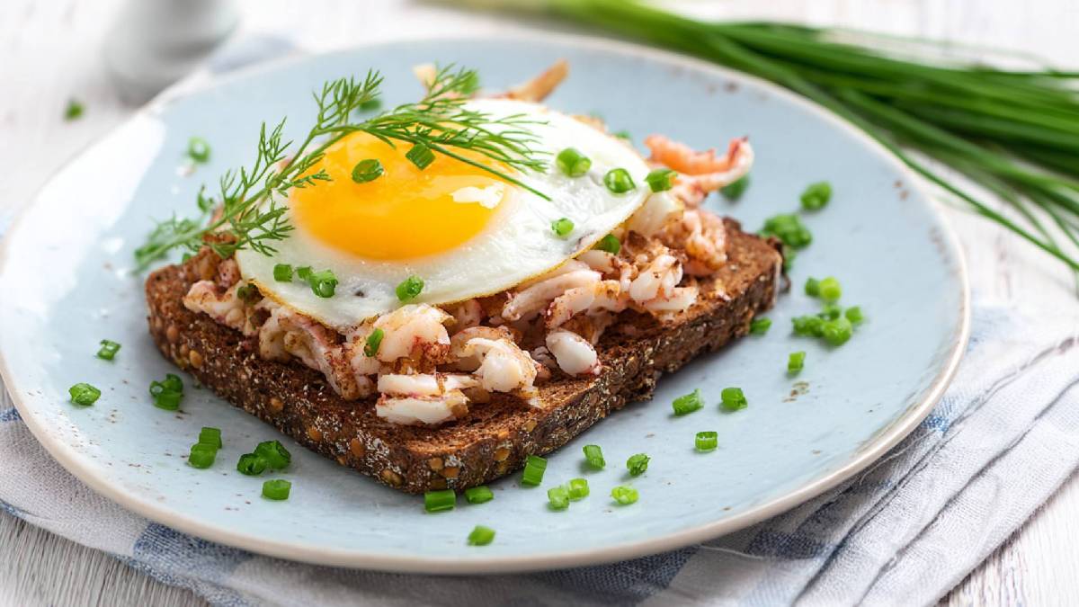 Teller mit einem Halligbrot mit Krabben und Spiegelei