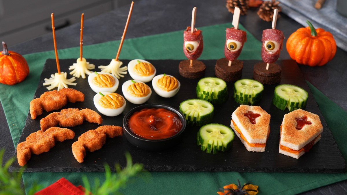 Verschiedenes Halloween-Fingerfood auf einem Schieferbrett.