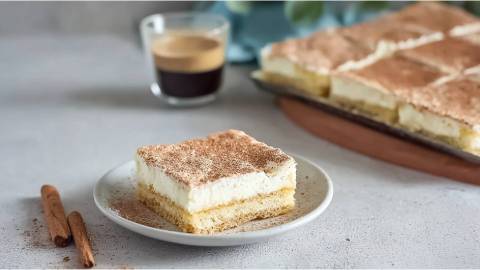 Teller und ein Blech mit Norddeutscher Schmandkuchen, in Stücke geschnitten
