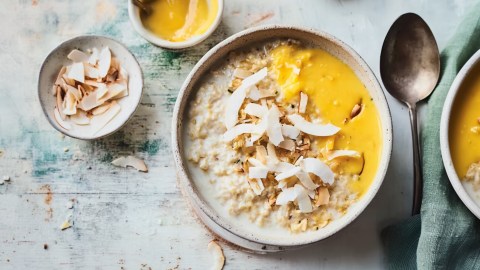 Eine Schüssel White Choc Porridge mit Kokos-Mango-Topping.