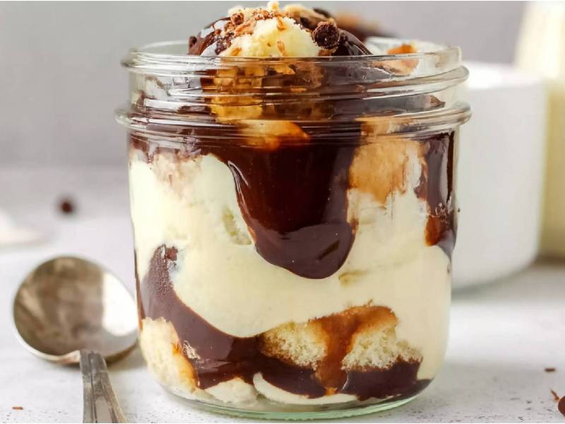 Glas mit Boston Cream Dessert auf einem Tisch Löffel daneben