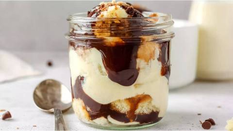 Glas mit Boston Cream Dessert auf einem Tisch Löffel daneben