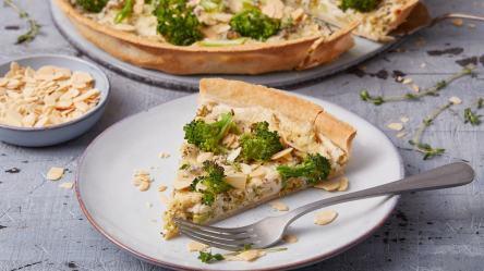 Ein Stück Brokkoli-Hähnchen-Quiche auf einem hellen Teller.