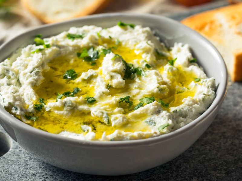 Eine Schale Lauch-Feta-Aufstrich mit Olivenöl.