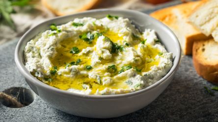 Eine Schale Lauch-Feta-Aufstrich mit Olivenöl.