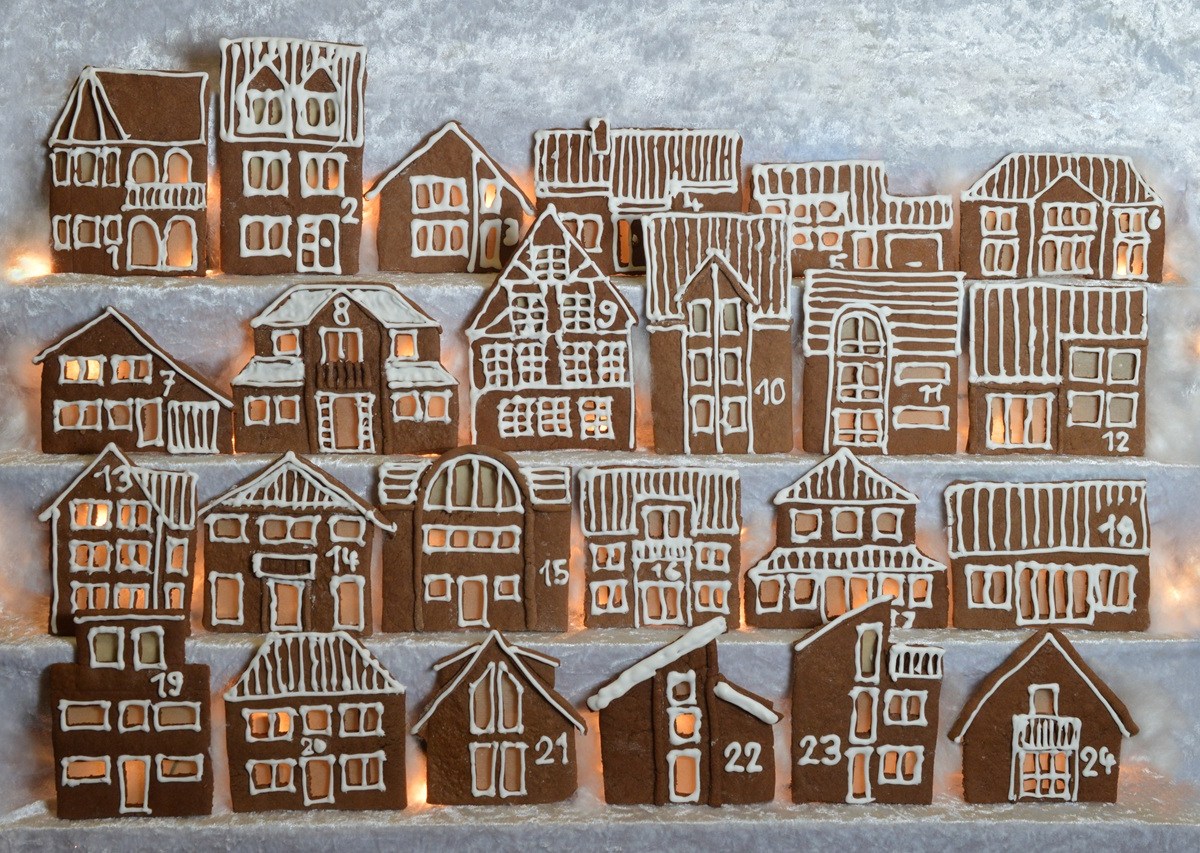 Geschenke aus der Küche für den Adventskalender: Ein essbarer Adventskalender aus Lebkuchenhäuschen, verziert mit Zahlen aus Zuckerguss.