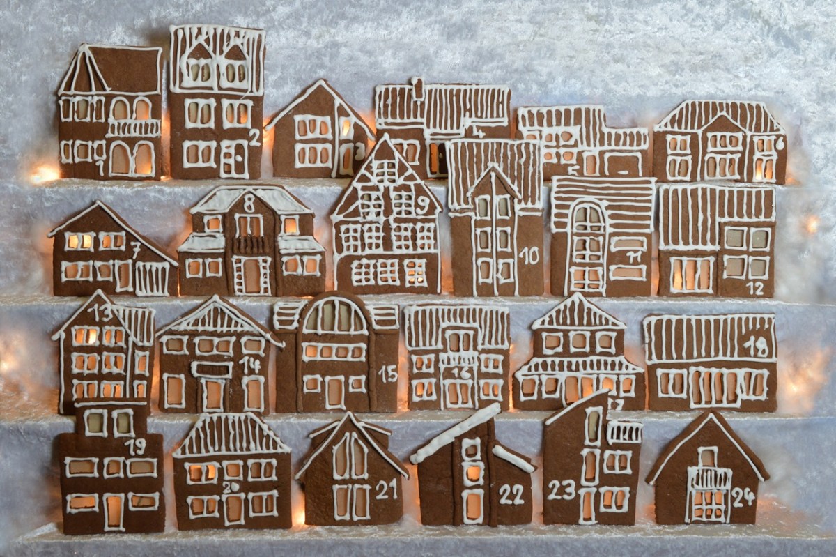Geschenke aus der Küche für den Adventskalender: Ein essbarer Adventskalender aus Lebkuchenhäuschen, verziert mit Zahlen aus Zuckerguss.