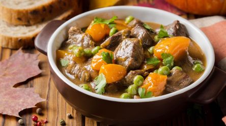 Eine Schale Kürbis-Rinder-Gulasch mit Erbsen.