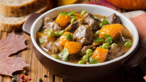 Eine Schale Kürbis-Rinder-Gulasch mit Erbsen.