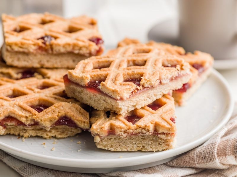 Mehrere Stücke Linzer Torte vom Blech auf einem Teller.