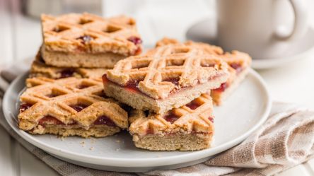 Mehrere Stücke Linzer Torte vom Blech auf einem Teller.