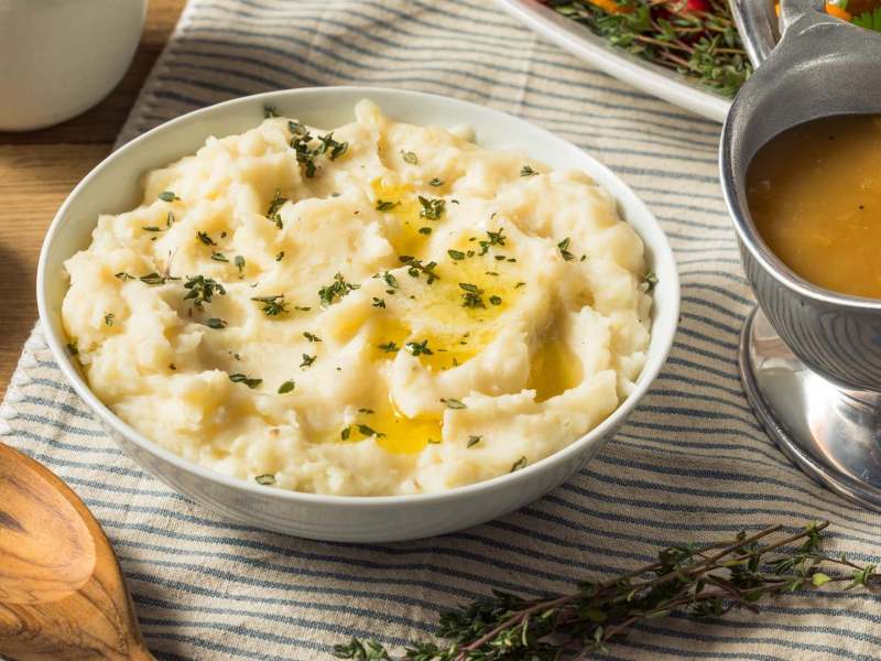 Eine Schale Miso-Kartoffelpüree, garniert mit geschmolzener Butter und Thymian.