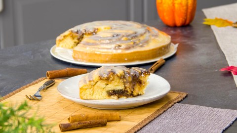 Ein Stück Zimt-Kuchen, der Rest des Kuchens steht im Hintergrund.